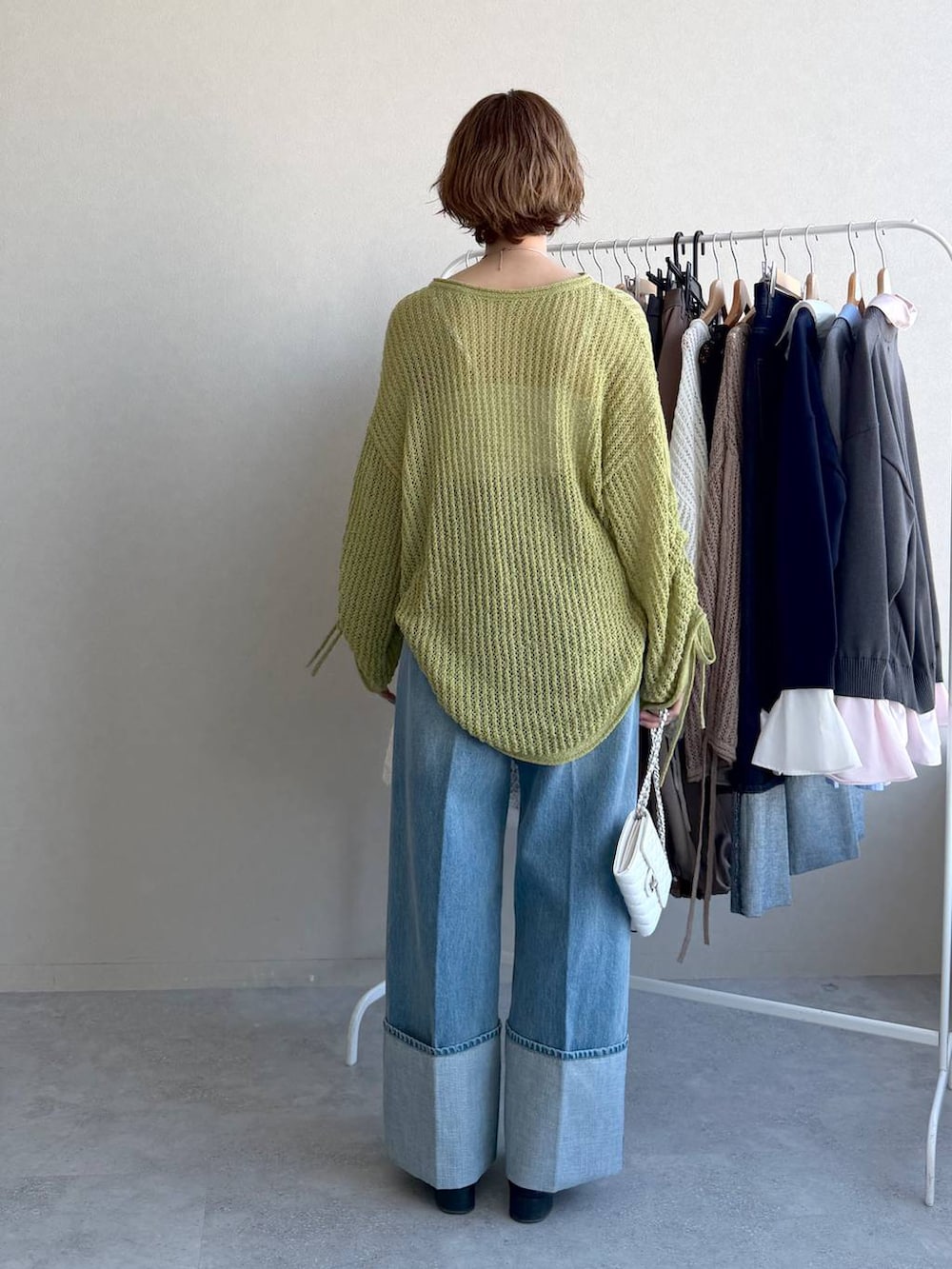 ブラック系のローファー、グリーン系のニット/セーター、ブルー系のデニムパンツを着用したレディースの冬コーディネートの3枚目の写真