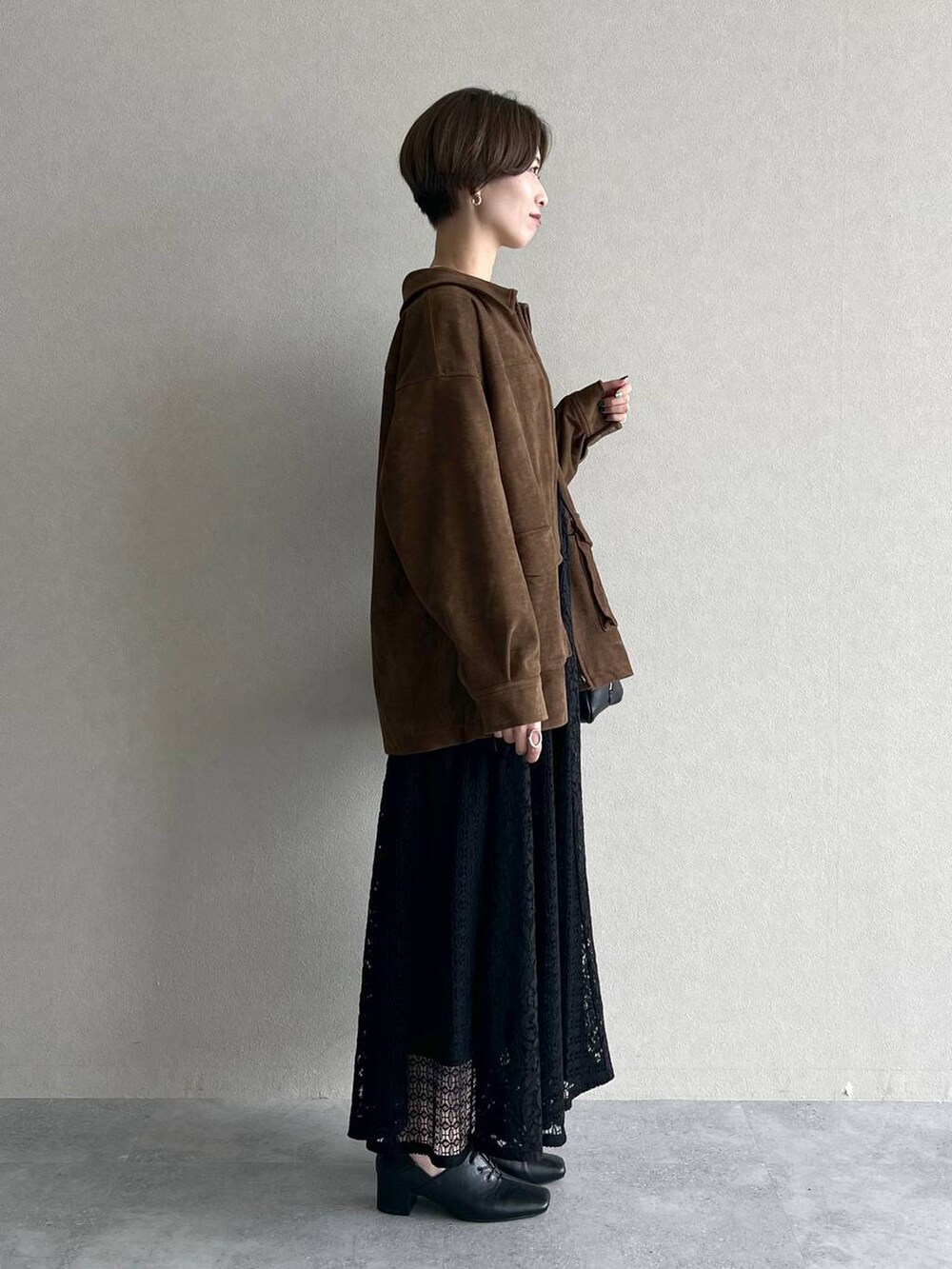 ブラック系のハンドバッグ、ブラック系のワンピース、ブラック系のドレスシューズを着用したレディースの秋コーディネートの2枚目の写真