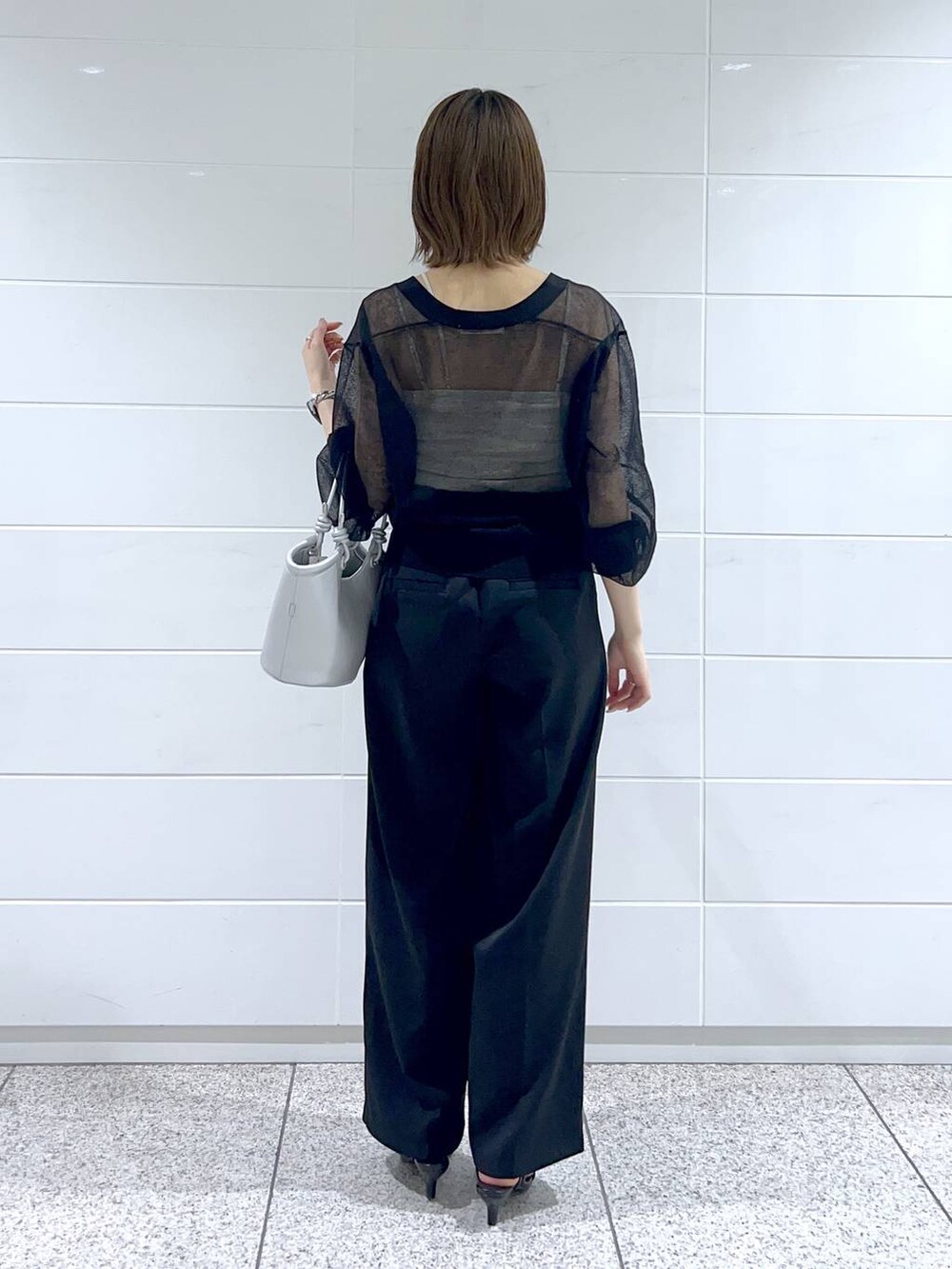 ホワイト系のキャミソール、ブラック系のサンダル、シルバー系のハンドバッグを着用したレディースの春コーディネートの3枚目の写真