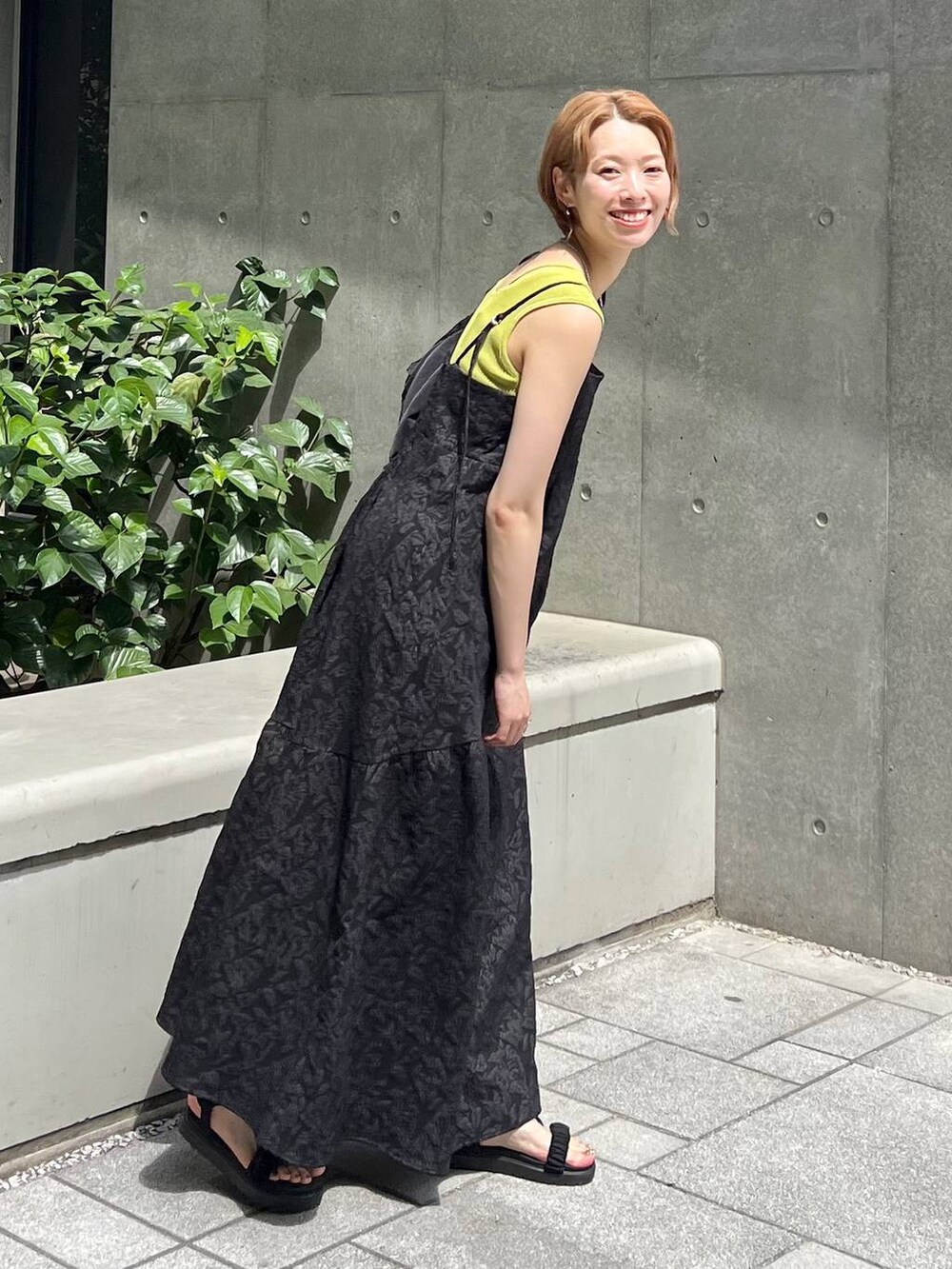 ブラック系のサンダル、グリーン系のニット/セーター、ブラック系のワンピースを着用したレディースの夏コーディネートの3枚目の写真