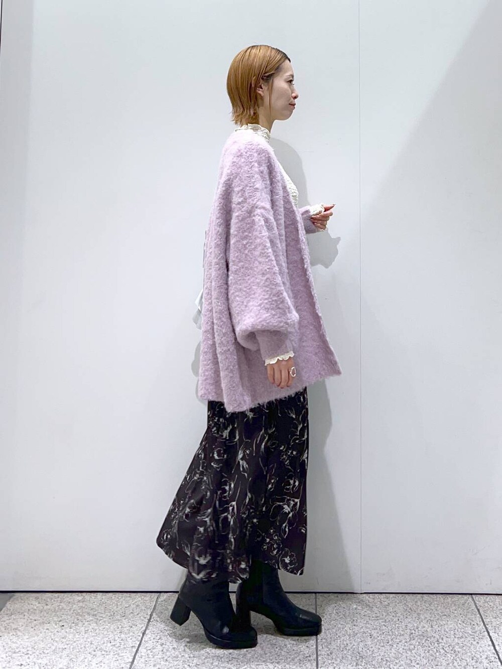 ブラック系のブーツ、ピンク系のカーディガン/ボレロ、シルバー系のトートバッグを着用したレディースの冬コーディネートの2枚目の写真