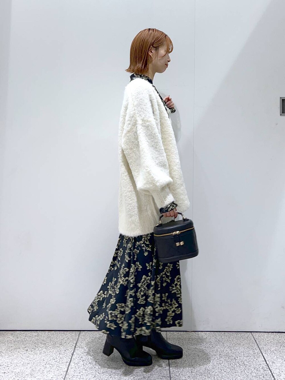 ブラック系のブーツ、ブラック系のスカート、ブラック系のシャツ/ブラウスを着用したレディースの秋コーディネートの2枚目の写真