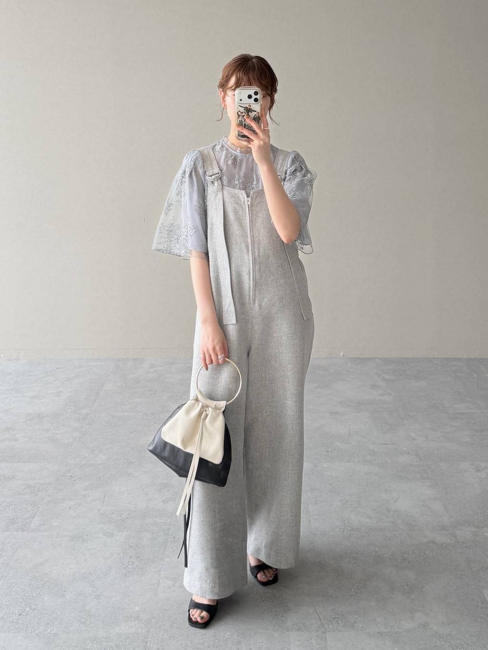 ブルー系のシャツ/ブラウス、ブラック系のハンドバッグ、ブラック系のサンダルを着用したレディースの春コーディネートの5枚目の写真