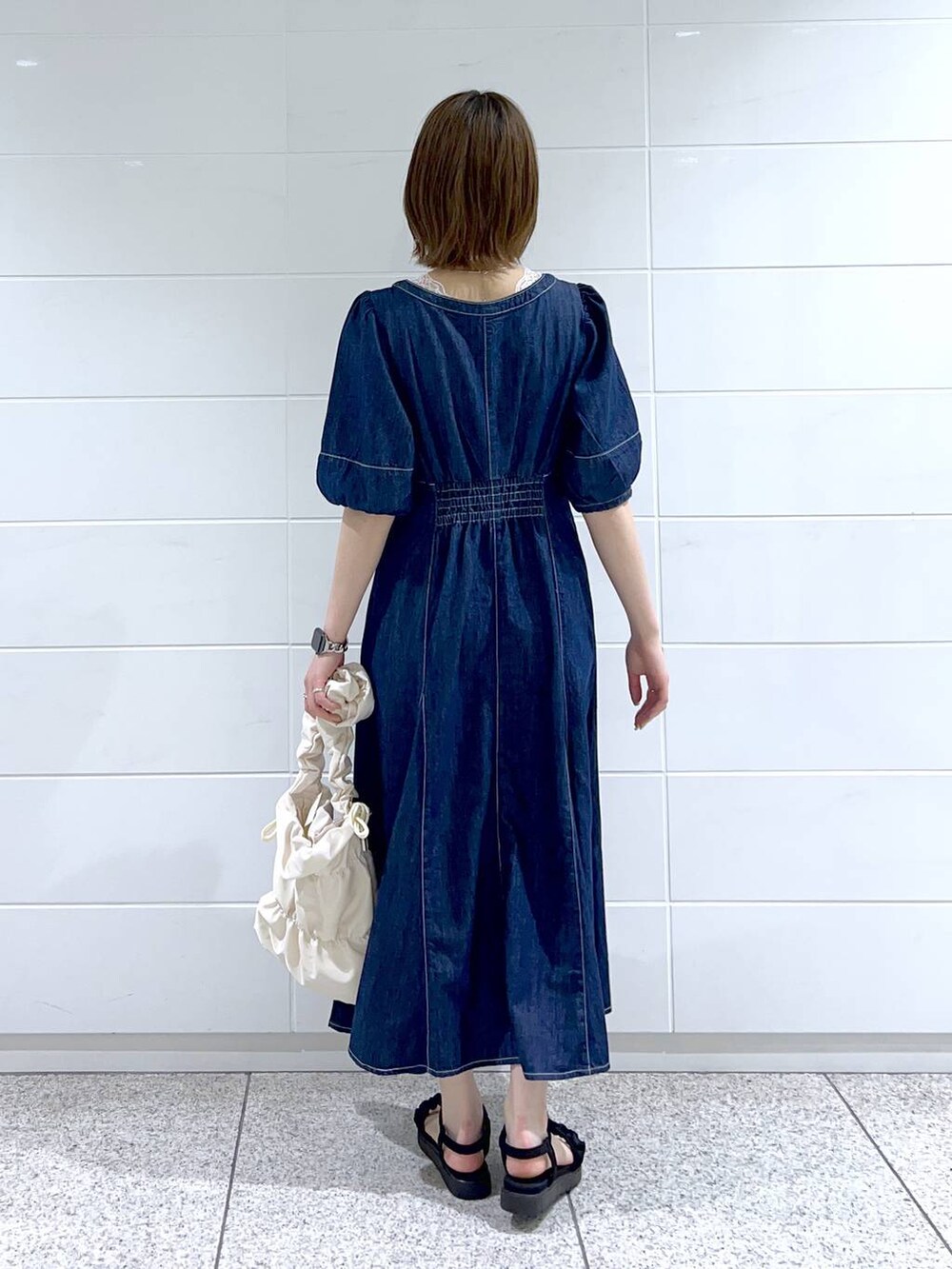 ホワイト系のショルダーバッグ、ホワイト系のタンクトップ、ブルー系のワンピースを着用したレディースの春コーディネートの3枚目の写真