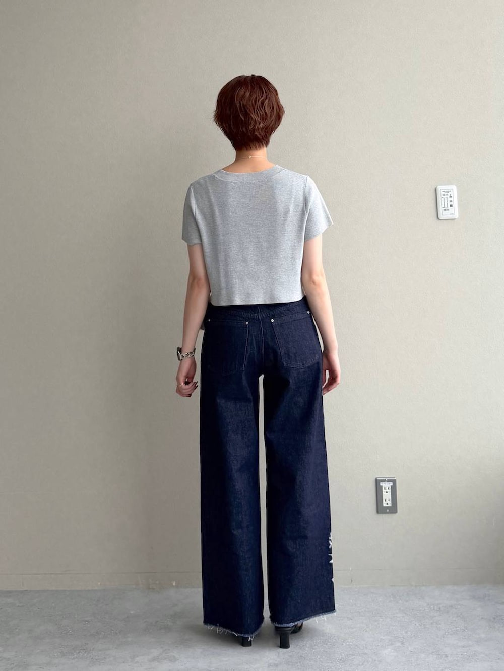 グレー系のニット/セーター、ブルー系のデニムパンツ、ブラック系のサンダルを着用したレディースの夏コーディネートの3枚目の写真