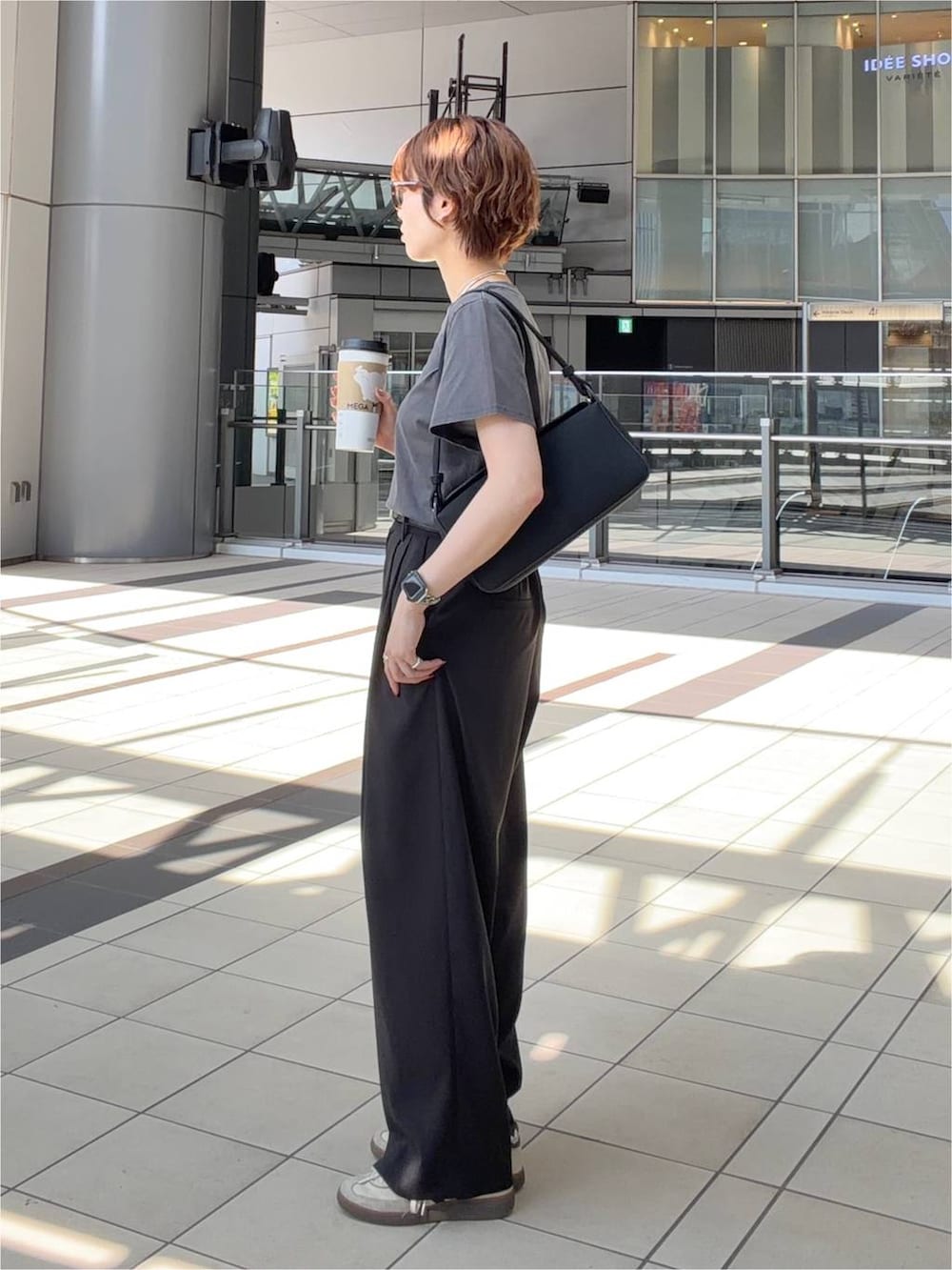 グレー系のTシャツ/カットソー、ブラック系のショルダーバッグ、ブラウン系のサングラスを着用したレディースの夏コーディネートの2枚目の写真
