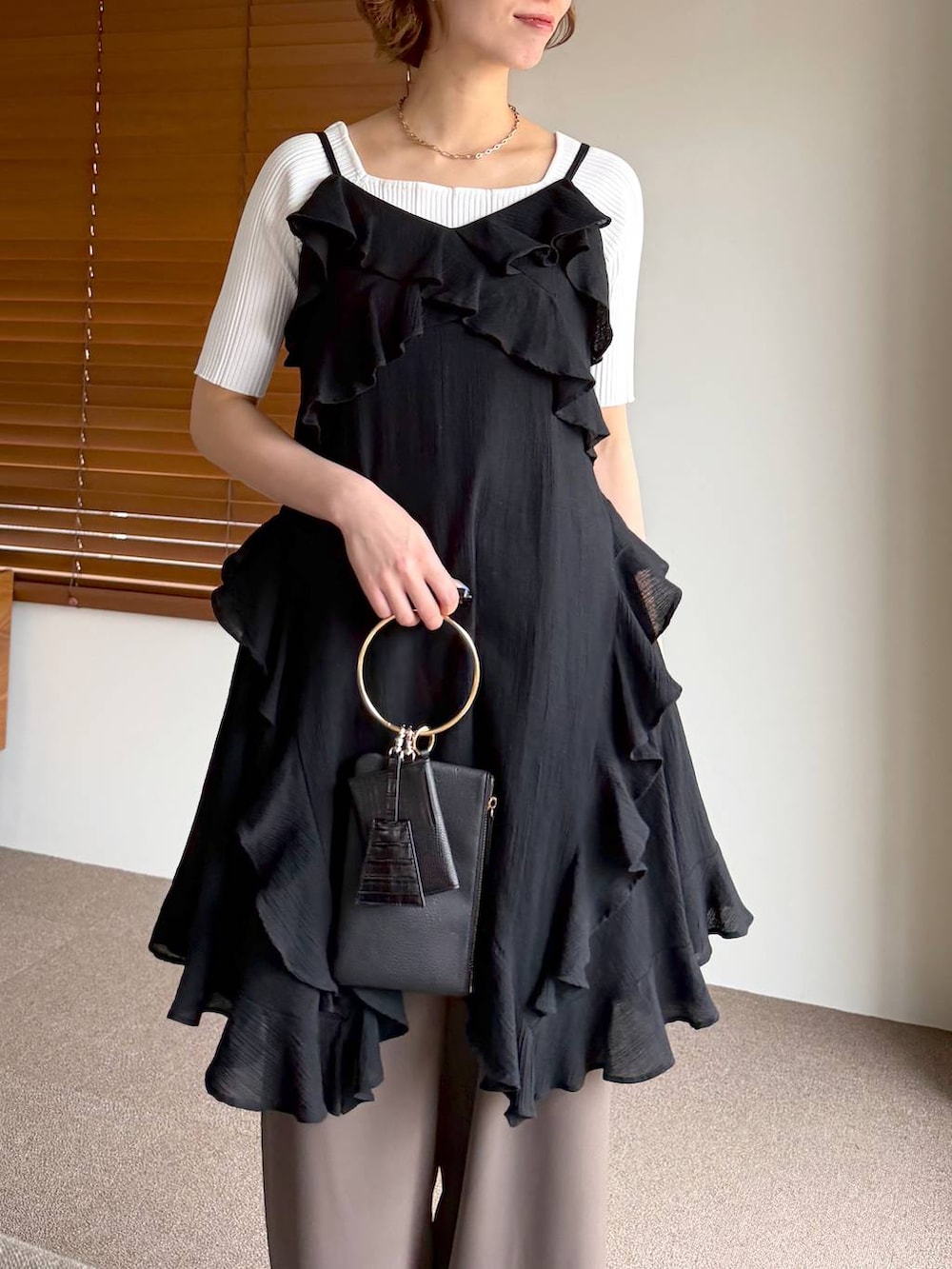 ブラック系のサンダル、ブラック系のショルダーバッグ、ブラック系のチュニックを着用したレディースの春コーディネートの4枚目の写真