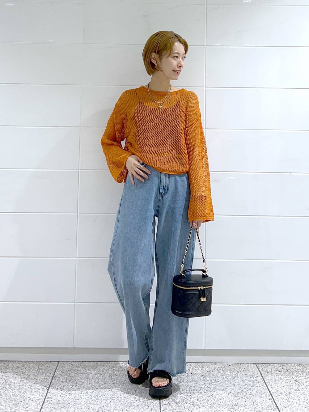 ブルー系のデニムパンツ、ブラック系のキャミソール、ブラック系のショルダーバッグを着用したレディースの夏コーディネートの2枚目の写真