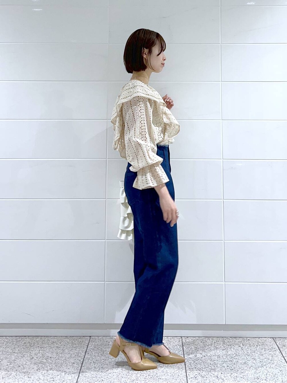 ホワイト系のシャツ/ブラウス、ベージュ系のパンプス、ホワイト系のトートバッグを着用したレディースの冬コーディネートの2枚目の写真