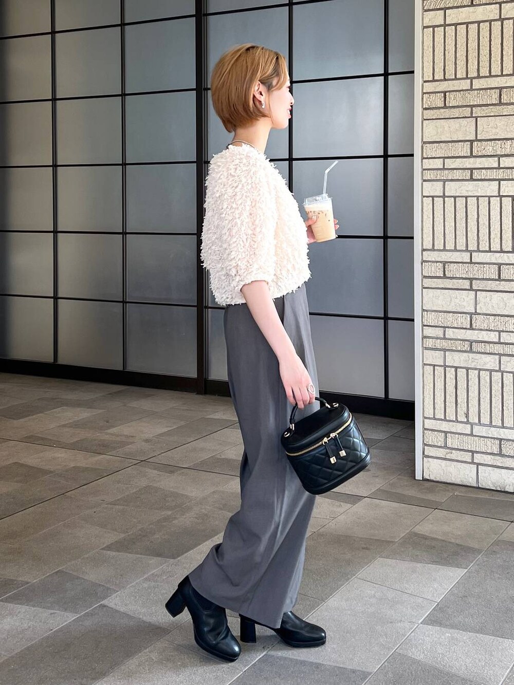 ホワイト系のカーディガン/ボレロ、ブラック系のショルダーバッグ、グレー系のその他パンツを着用したレディースの秋コーディネートの2枚目の写真