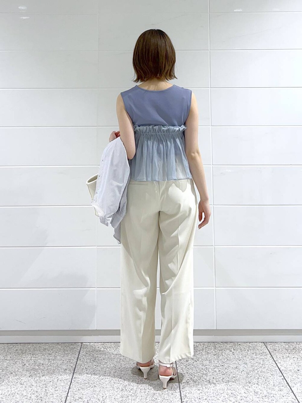 ブルー系のシャツ/ブラウス、ホワイト系のサンダル、ホワイト系のハンドバッグを着用したレディースの春コーディネートの6枚目の写真