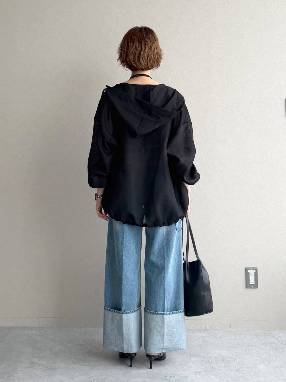 ブラック系のサンダル、ブルー系のデニムパンツ、ブラック系のキャミソールを着用したレディースの春コーディネートの3枚目の写真