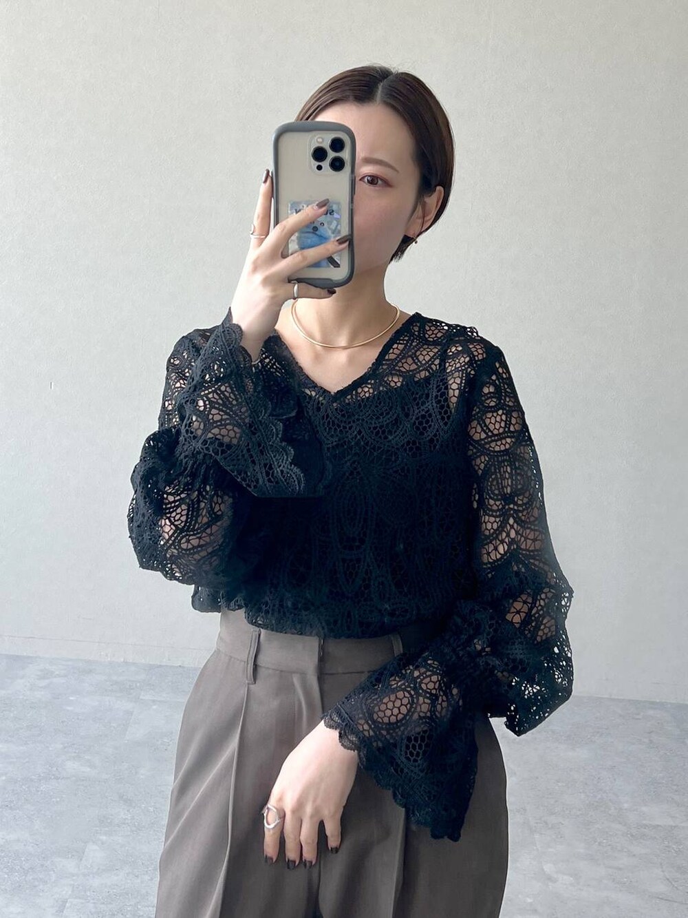 ブラック系のシャツ/ブラウス、ブラウン系のスラックス、ブラック系のローファーを着用したレディースの秋コーディネートの5枚目の写真