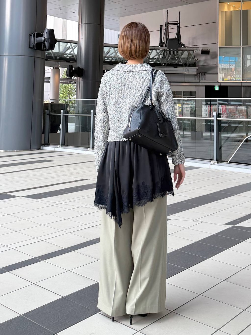 ブラック系のハンドバッグ、ブラック系のサンダル、ブラック系のキャミソールを着用したレディースの春コーディネートの3枚目の写真