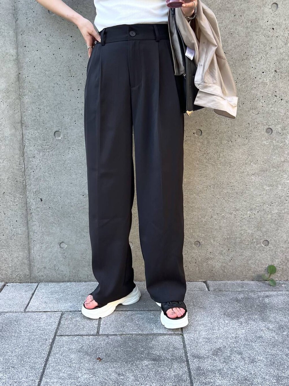 ブラック系のサンダル、ブラック系のスラックス、ブラック系のショルダーバッグを着用したレディースの夏コーディネートの5枚目の写真