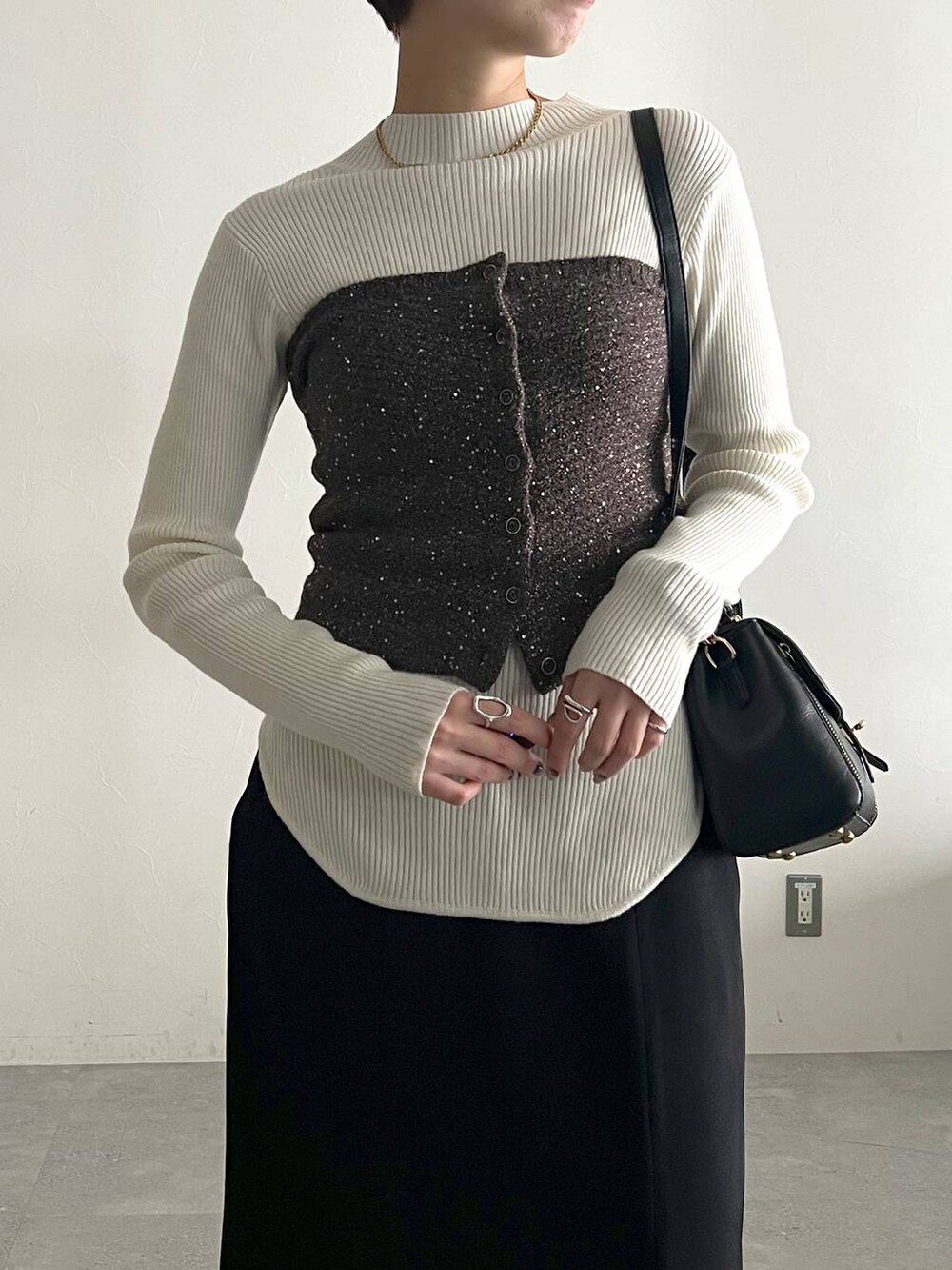 ホワイト系のニット/セーター、ブラック系のブーツ、ブラック系のスカートを着用したレディースの冬コーディネートの5枚目の写真