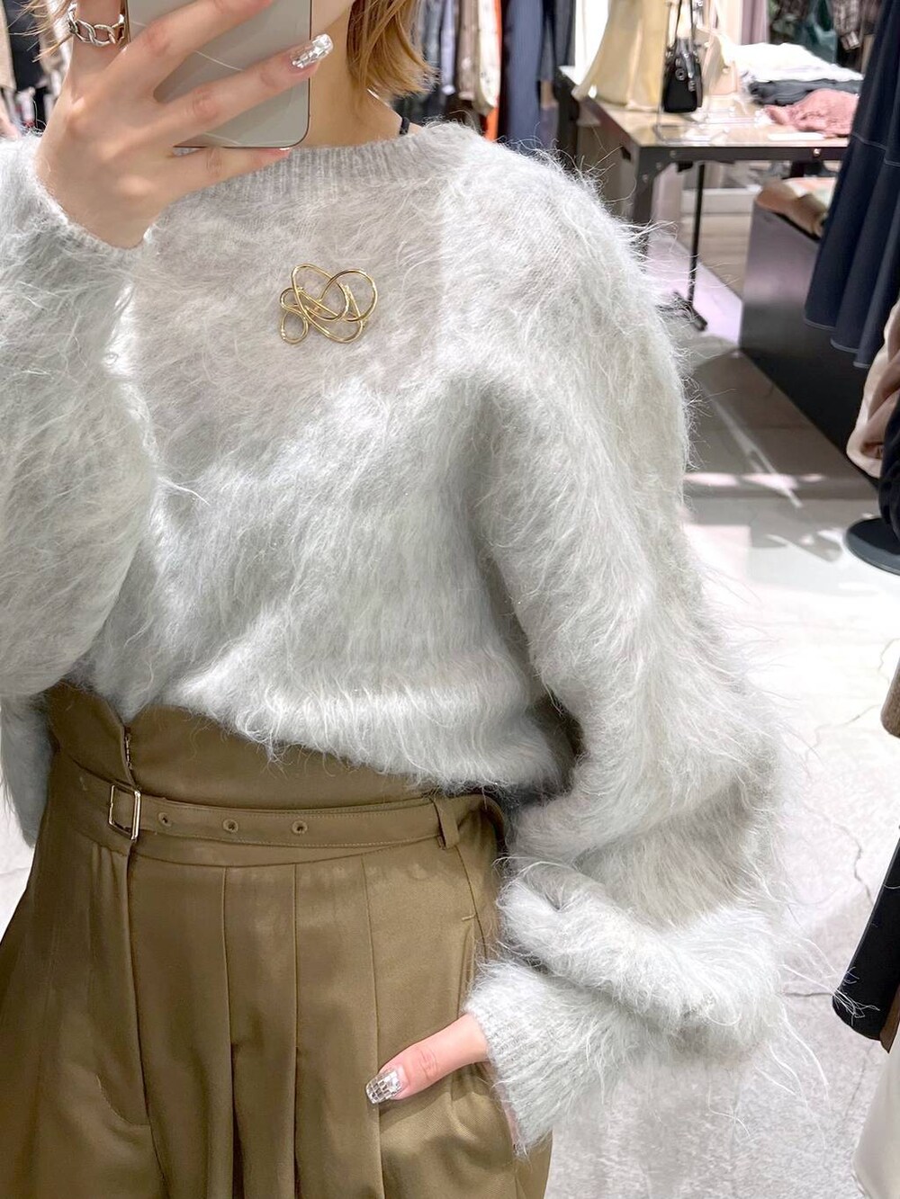 グレー系のカーディガン/ボレロ、ブラック系のブーツ、ブラック系のハンドバッグを着用したレディースの秋コーディネートの5枚目の写真