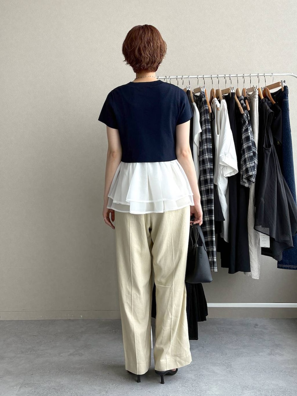 ブルー系のニット/セーター、ベージュ系のその他パンツ、ブラック系のショルダーバッグを着用したレディースの夏コーディネートの3枚目の写真