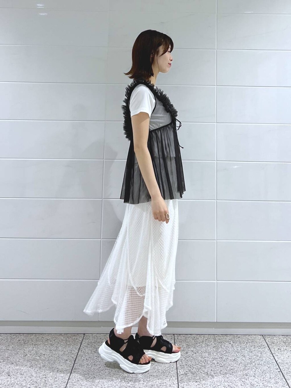 ブラック系のサンダル、ホワイト系のTシャツ/カットソー、ブラック系のショルダーバッグを着用したレディースの夏コーディネートの3枚目の写真