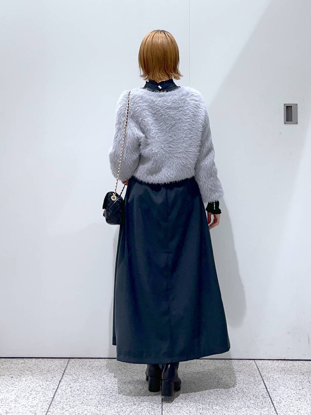 ブラック系のショルダーバッグ、ブラック系のブーツ、ブラック系のシャツ/ブラウスを着用したレディースの冬コーディネートの3枚目の写真