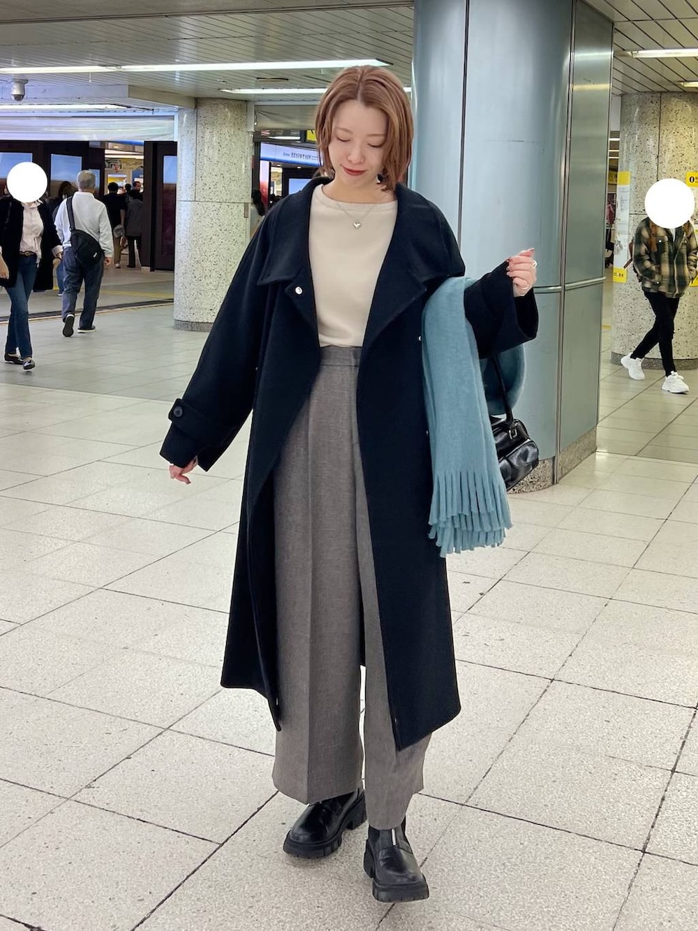 ブラック系のチェスターコート、グレー系のその他パンツ、ホワイト系のニット/セーターを着用したレディースの秋コーディネートの2枚目の写真