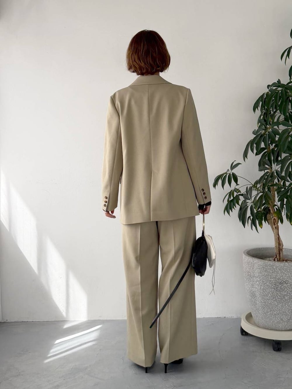 ベージュ系のテーラードジャケット、ベージュ系のその他パンツ、ブラック系のサンダルを着用したレディースの春コーディネートの3枚目の写真