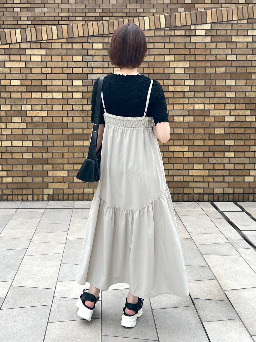 ブラック系のサンダル、ブラック系のTシャツ/カットソー、ブラック系のショルダーバッグを着用したレディースの夏コーディネートの3枚目の写真