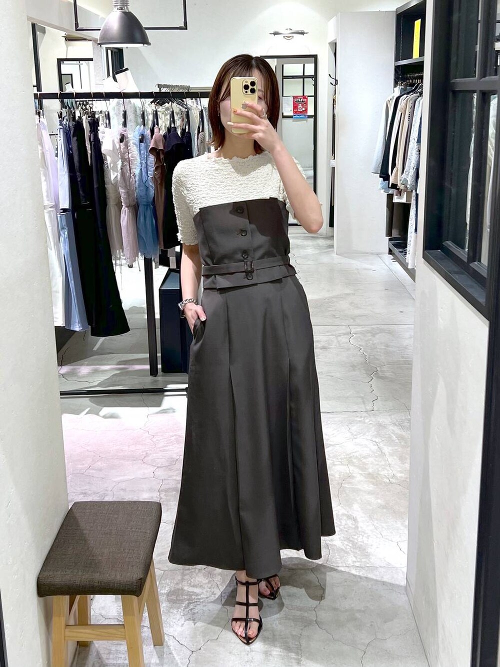 グレー系のスカート、ホワイト系のTシャツ/カットソー、ブラック系のショルダーバッグを着用したレディースの春コーディネートの5枚目の写真