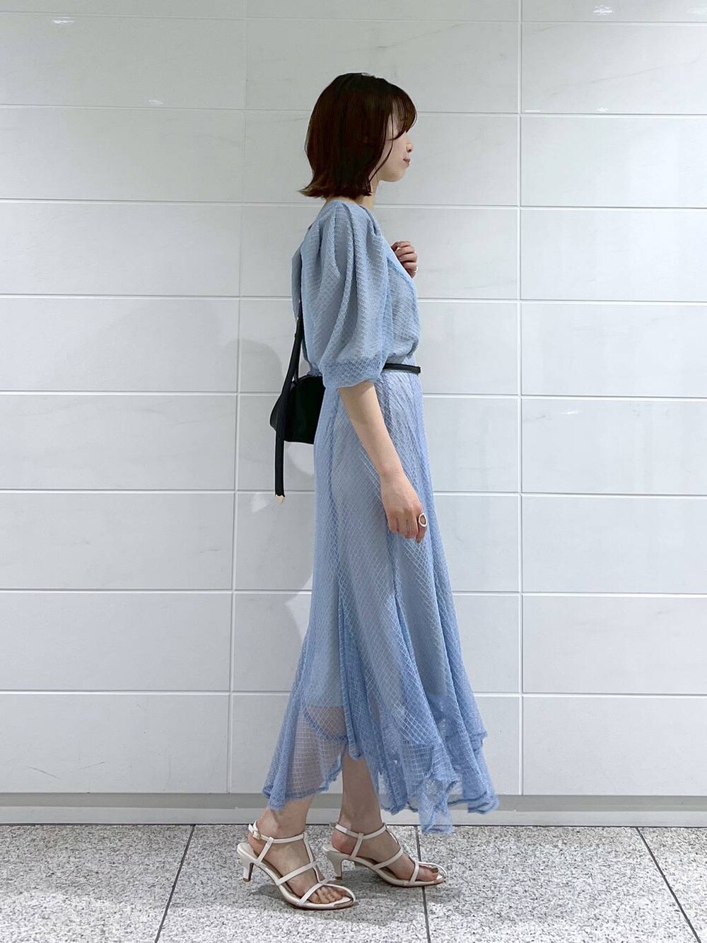 ブラック系のショルダーバッグ、ホワイト系のサンダル、ブルー系のスカートを着用したレディースの夏コーディネートの2枚目の写真