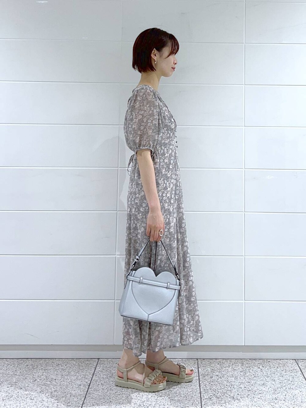 グレー系のサンダル、グレー系のワンピース、シルバー系のショルダーバッグを着用したレディースの夏コーディネートの3枚目の写真
