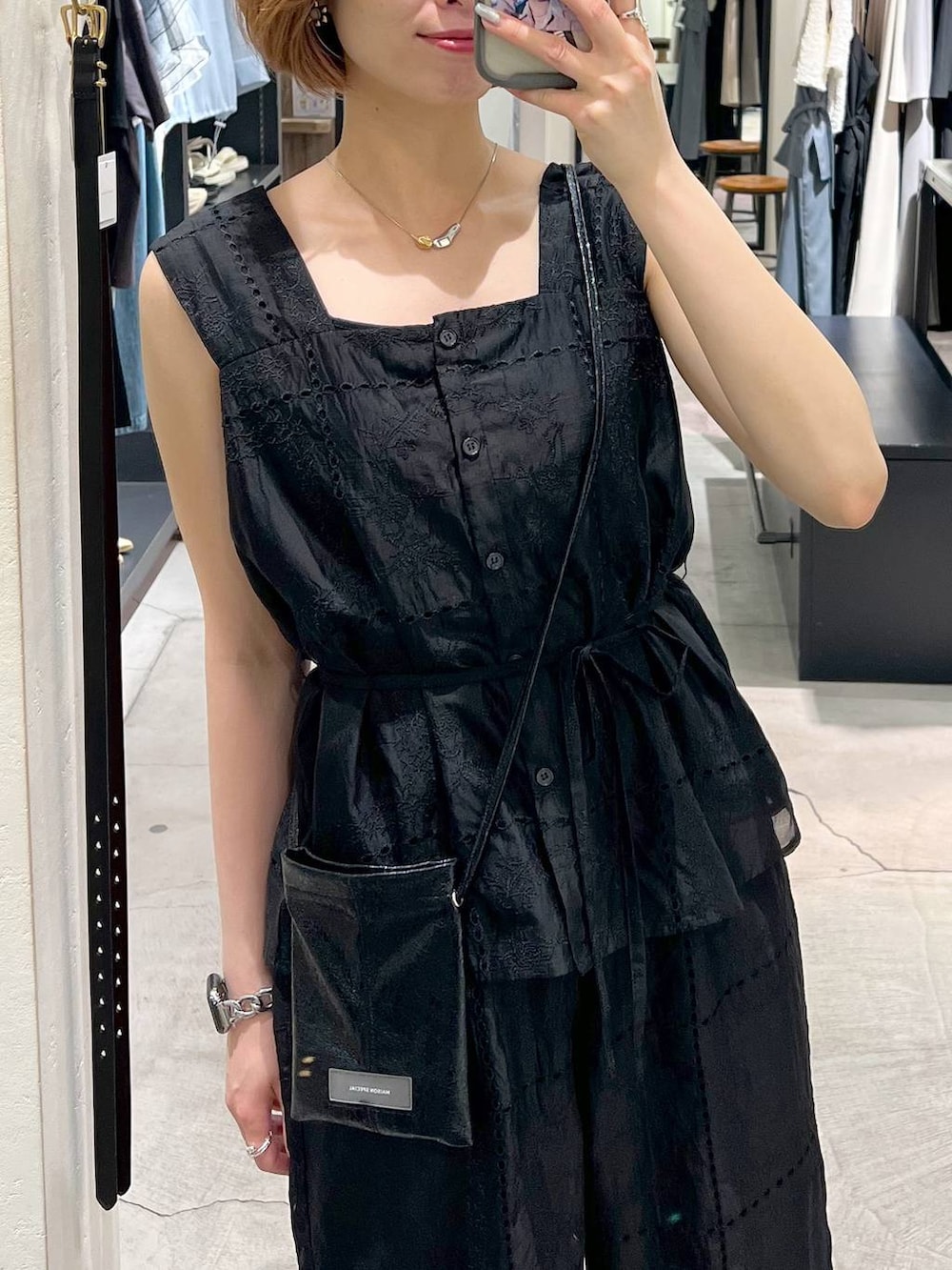 ブラック系のパンプス、ホワイト系のショルダーバッグ、ブラック系のシャツ/ブラウスを着用したレディースの夏コーディネートの5枚目の写真