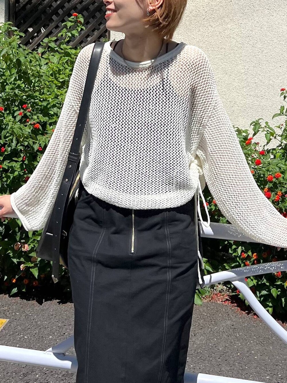 ブラック系のスカート、ブラック系のキャミソール、ホワイト系のニット/セーターを着用したレディースの秋コーディネートの2枚目の写真