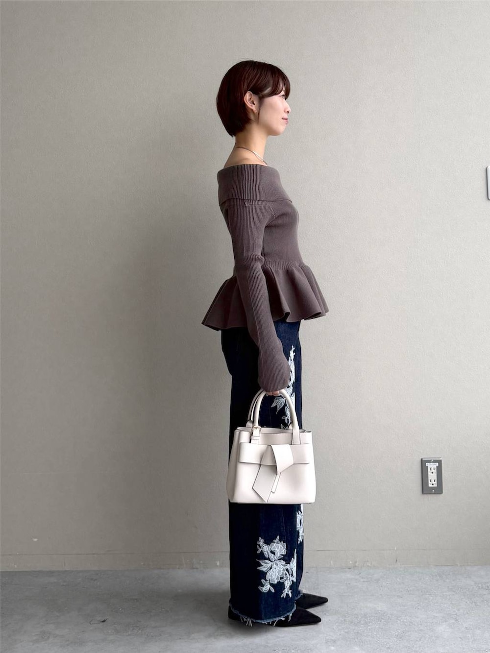 ブラック系のサンダル、ブルー系のデニムパンツ、ブラウン系のニット/セーターを着用したレディースの秋コーディネートの2枚目の写真