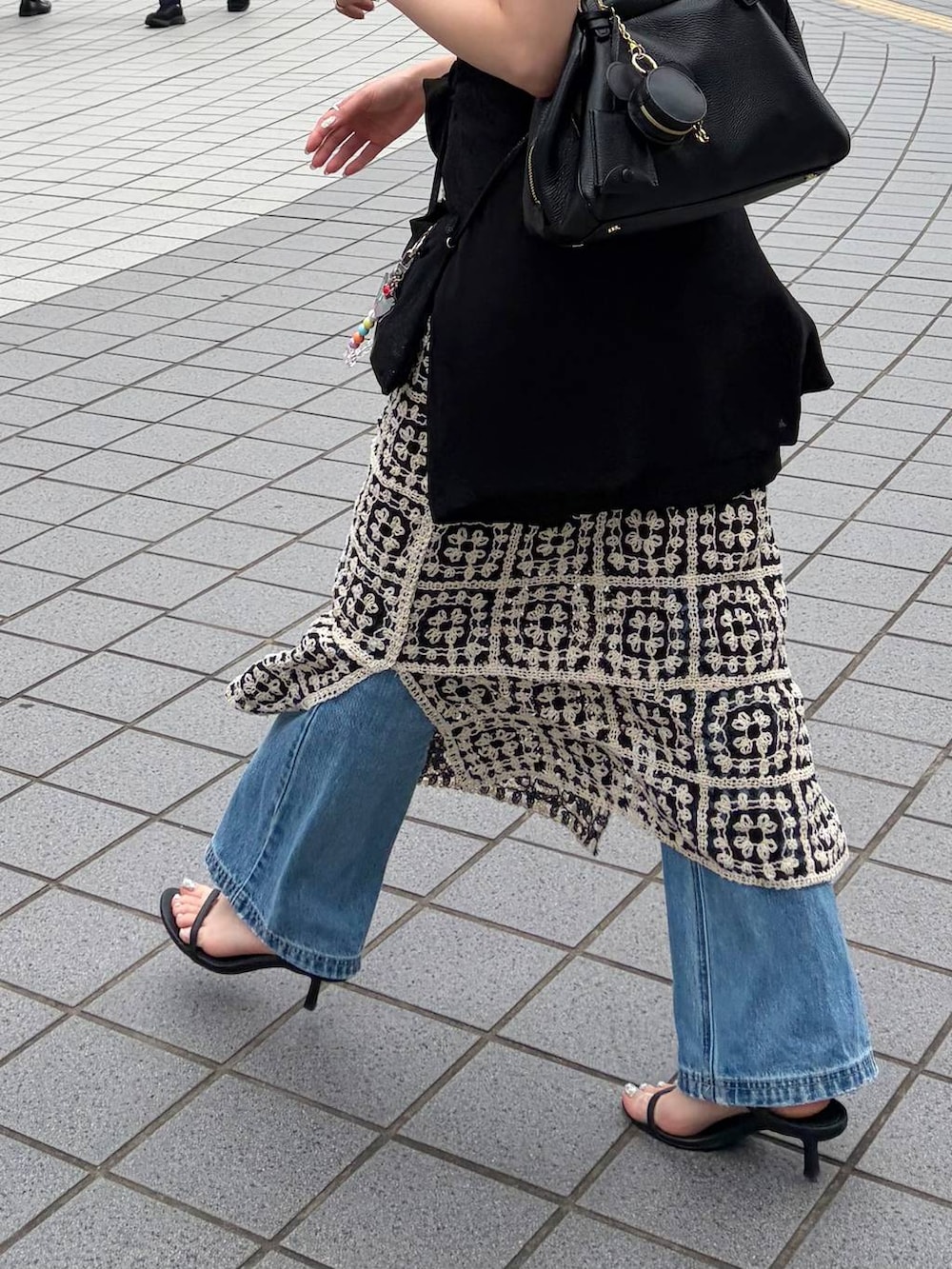 その他のワンピース、ブラック系のハンドバッグ、ブルー系のデニムパンツを着用したレディースの夏コーディネートの5枚目の写真
