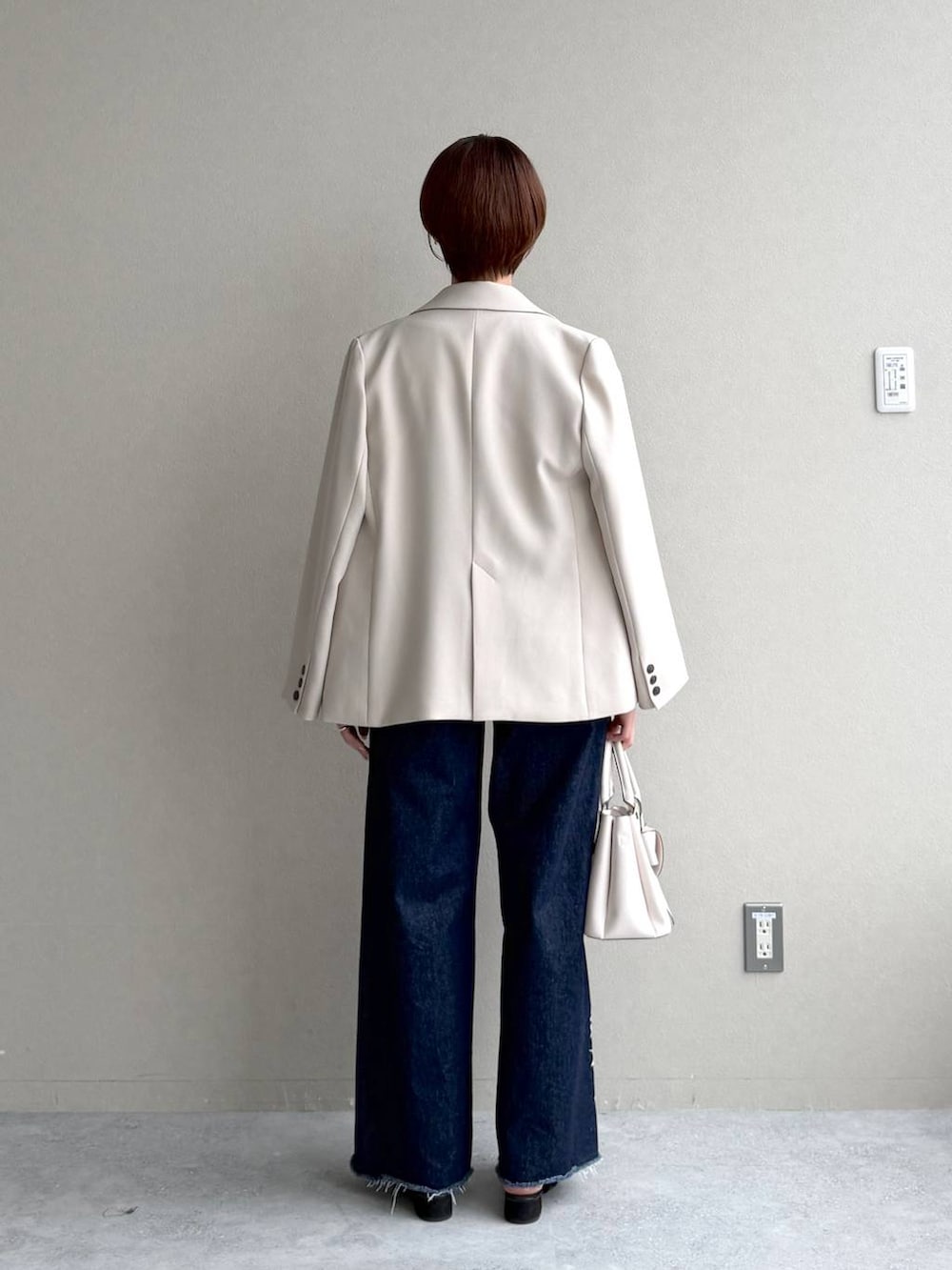 ブラック系のサンダル、ブルー系のデニムパンツ、ブラック系のTシャツ/カットソーを着用したレディースの秋コーディネートの3枚目の写真