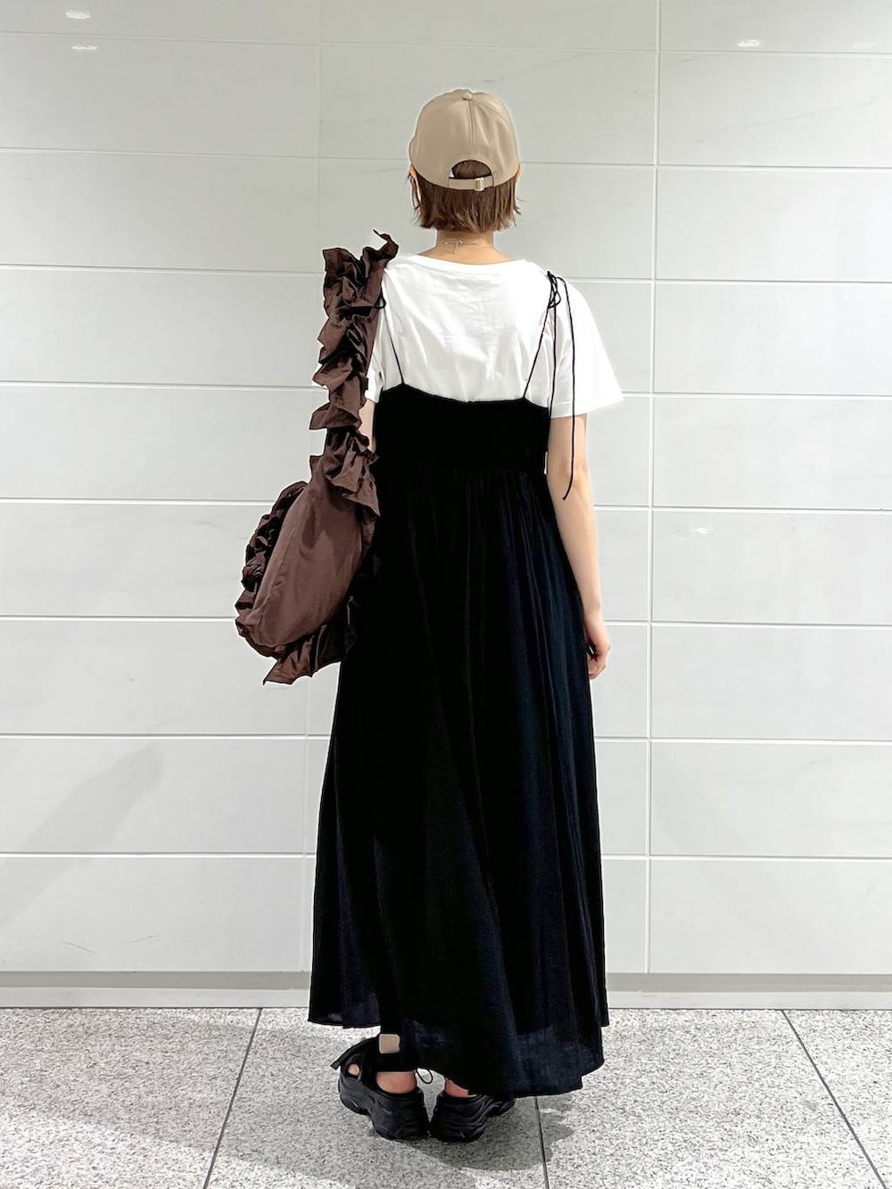 ブラック系のサンダル、ホワイト系のTシャツ/カットソー、ブラック系のワンピースを着用したレディースの春コーディネートの3枚目の写真