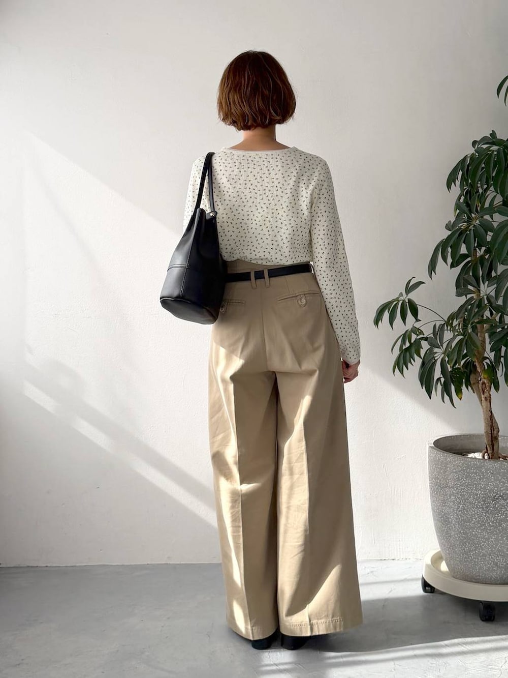 ホワイト系のTシャツ/カットソー、ベージュ系のチノパンツ、ブラック系のトートバッグを着用したレディースの春コーディネートの3枚目の写真