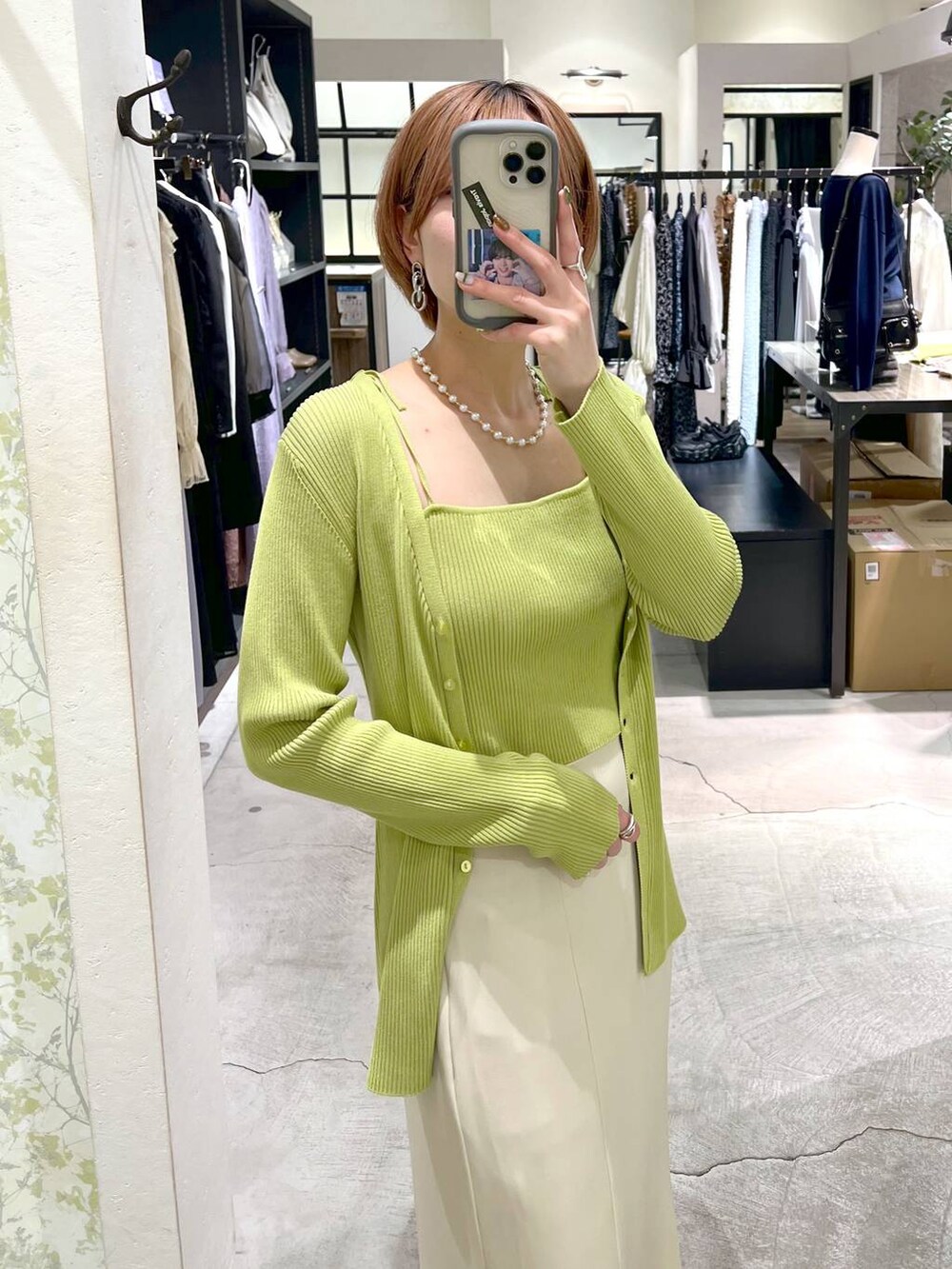 ベージュ系のスカート、シルバー系のバレエシューズ、グリーン系のカーディガン/ボレロを着用したレディースの春コーディネートの5枚目の写真