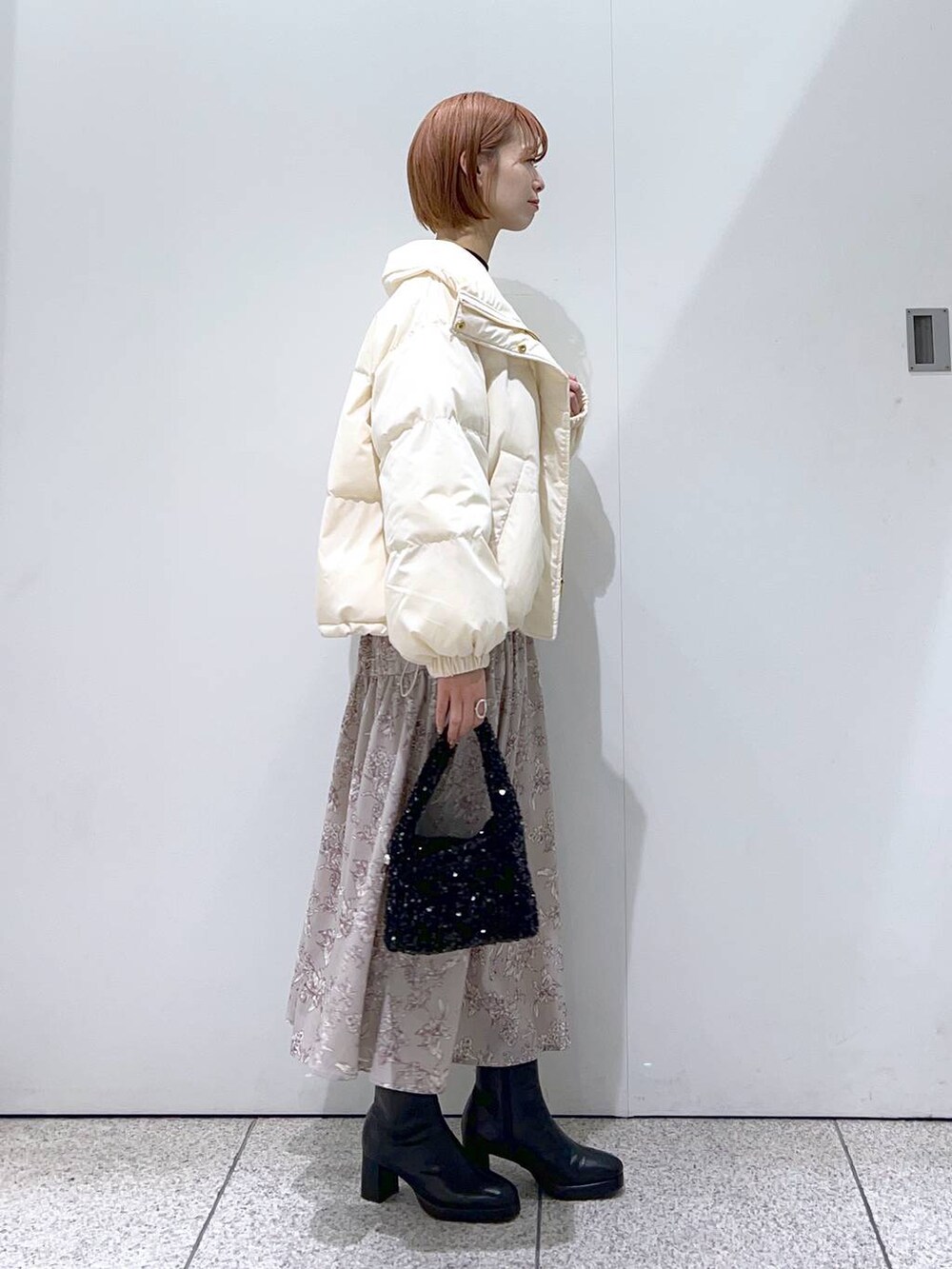 ブラック系のブーツ、ブラック系のニット/セーター、ブラック系のハンドバッグを着用したレディースの冬コーディネートの2枚目の写真