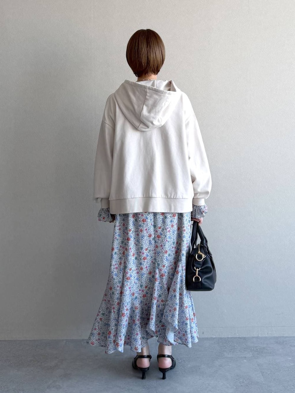 ブラック系のボストンバッグ、ホワイト系のパーカー、ブラック系のサンダルを着用したレディースの冬コーディネートの3枚目の写真