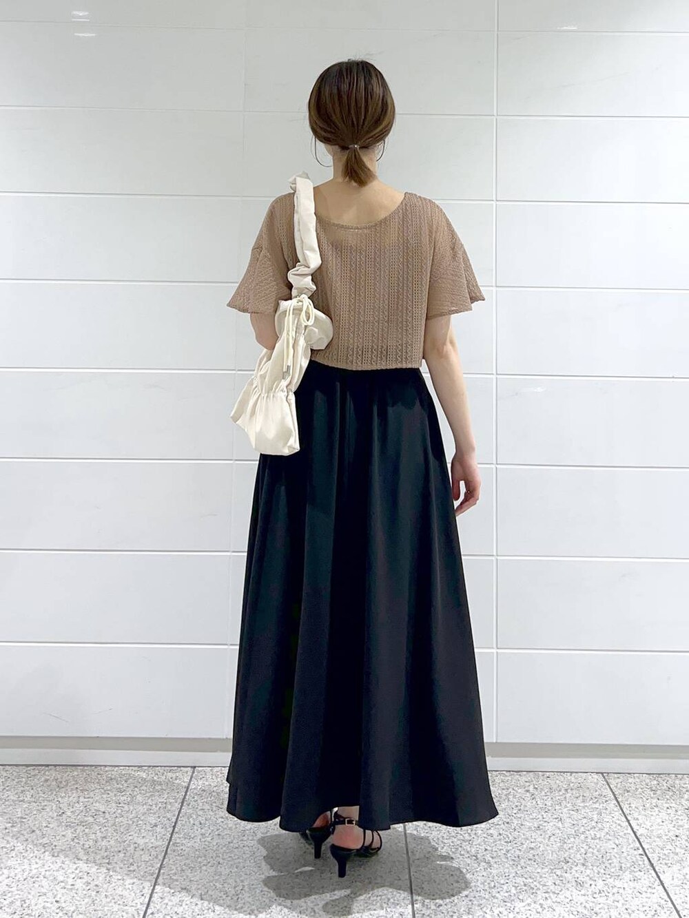 ホワイト系のショルダーバッグ、ブラウン系のカーディガン/ボレロ、ブラック系のサンダルを着用したレディースの夏コーディネートの3枚目の写真