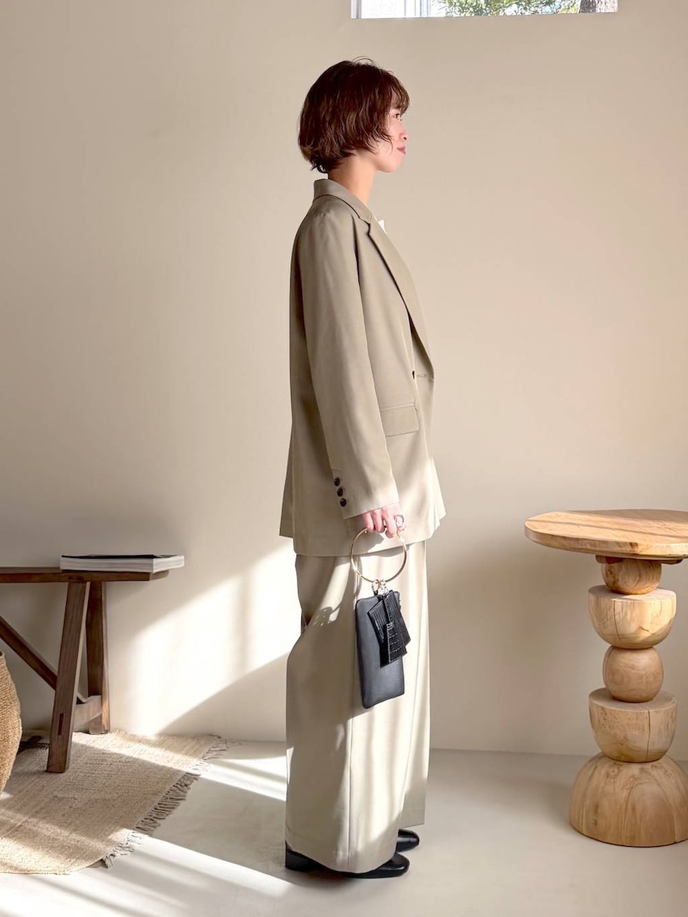 ブラック系のローファー、ブラック系のショルダーバッグ、ホワイト系のニット/セーターを着用したレディースの冬コーディネートの2枚目の写真