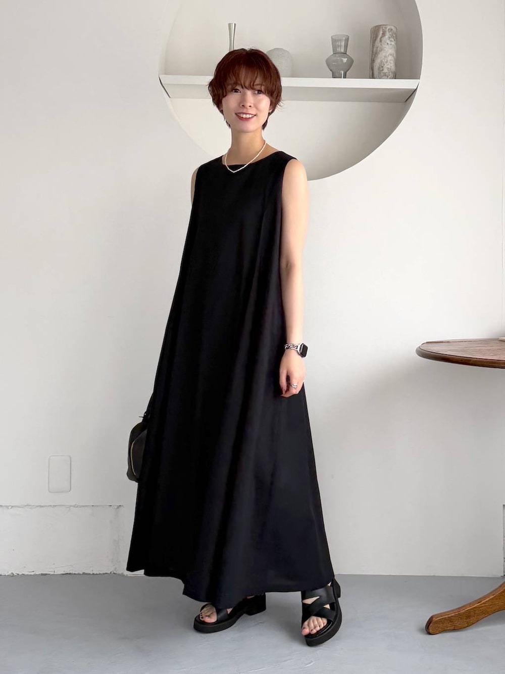ブラック系のワンピース、ブラック系のハンドバッグ、ブラック系のサンダルを着用したレディースの夏コーディネートの2枚目の写真
