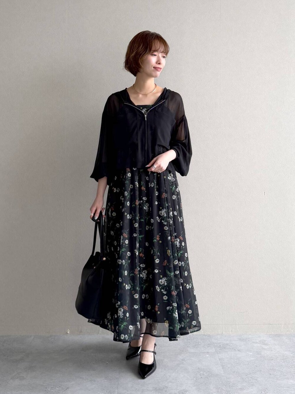 ブラック系のパーカー、ブラック系のサンダル、ブラック系のワンピースを着用したレディースの春コーディネートの5枚目の写真