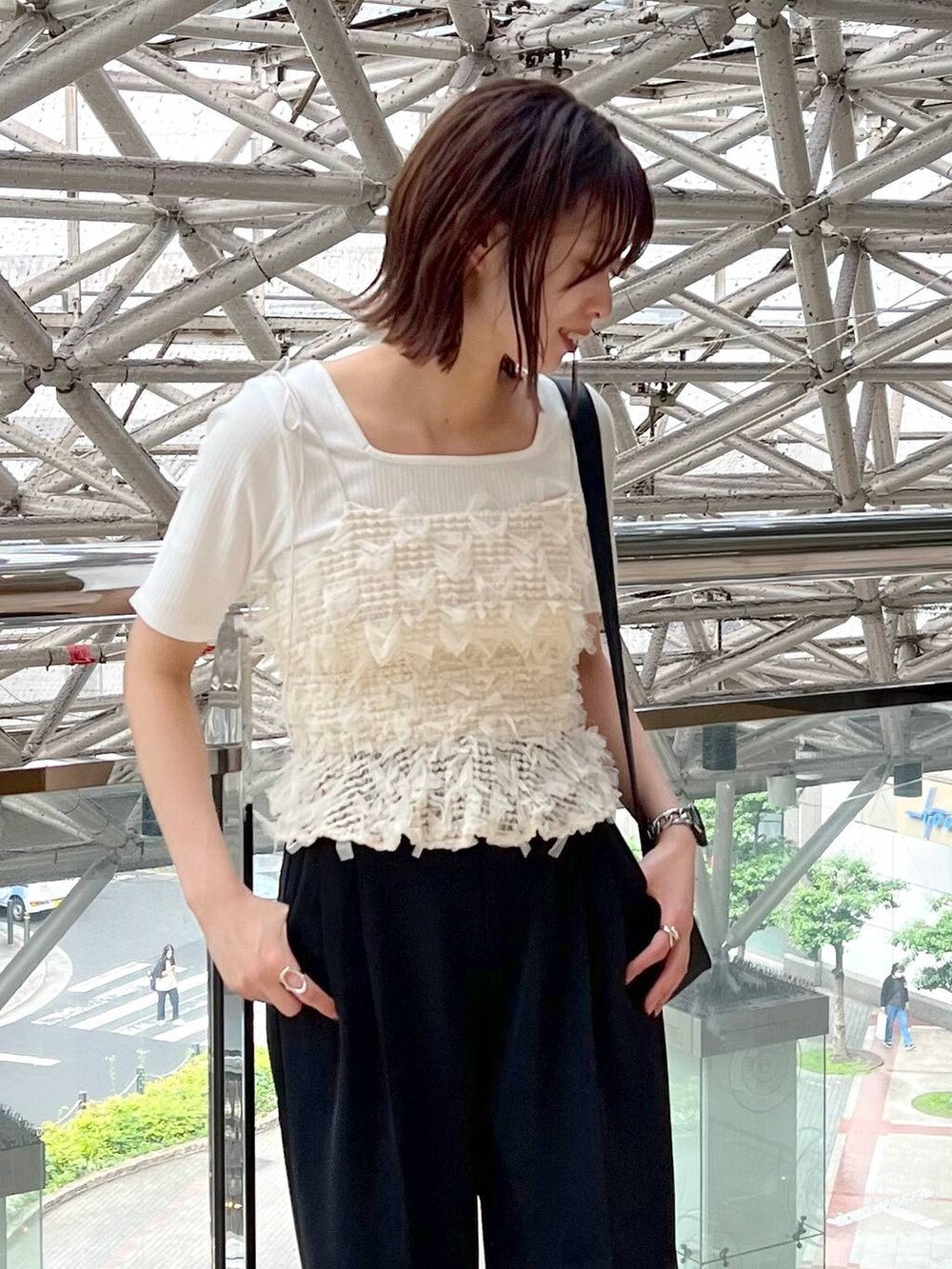 ブラック系のサンダル、ブラック系のスラックス、ブラック系のショルダーバッグを着用したレディースの春コーディネートの3枚目の写真