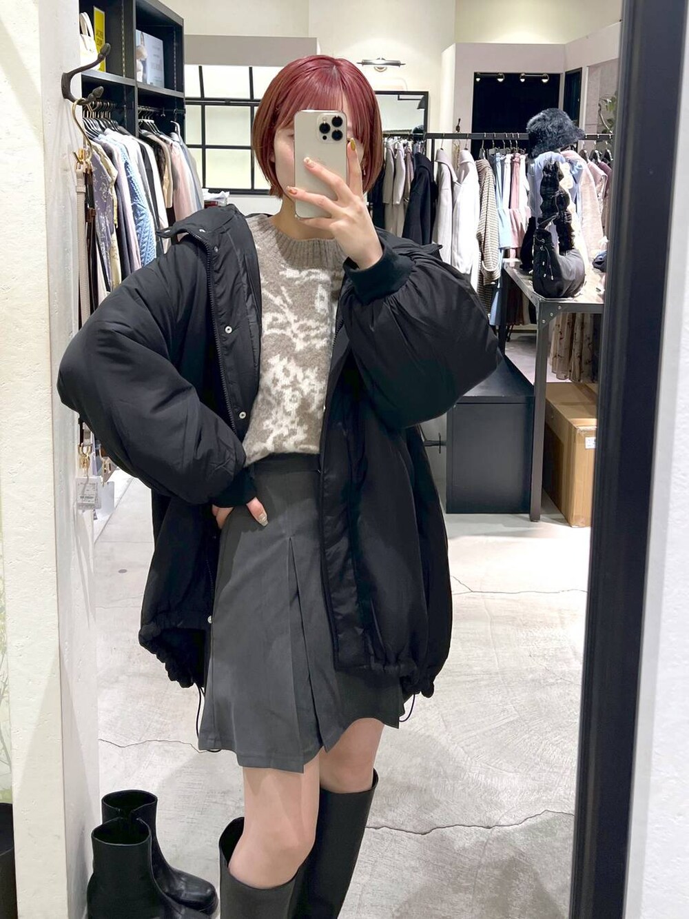 ブラック系のブルゾン、ホワイト系のボストンバッグ、ブラック系のブーツを着用したレディースの秋コーディネートの7枚目の写真