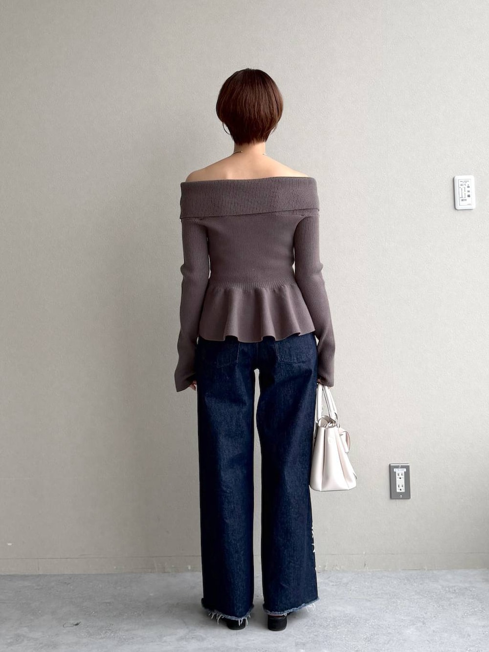 ブラック系のサンダル、ブルー系のデニムパンツ、ブラウン系のニット/セーターを着用したレディースの秋コーディネートの3枚目の写真