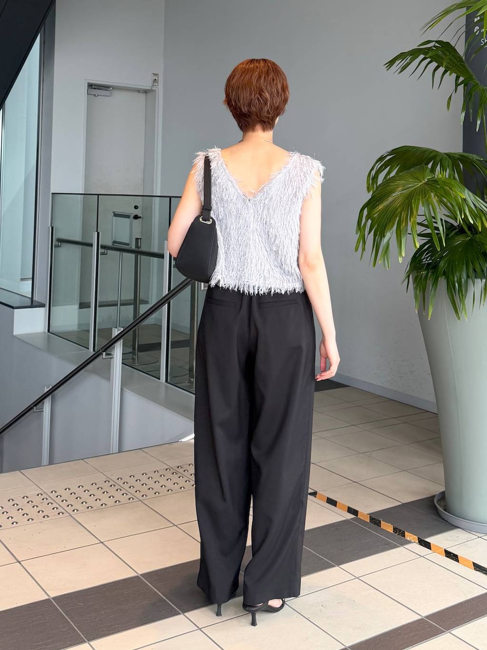 グレー系のベスト、ブラック系のその他パンツ、ブラック系のショルダーバッグを着用したレディースの夏コーディネートの3枚目の写真
