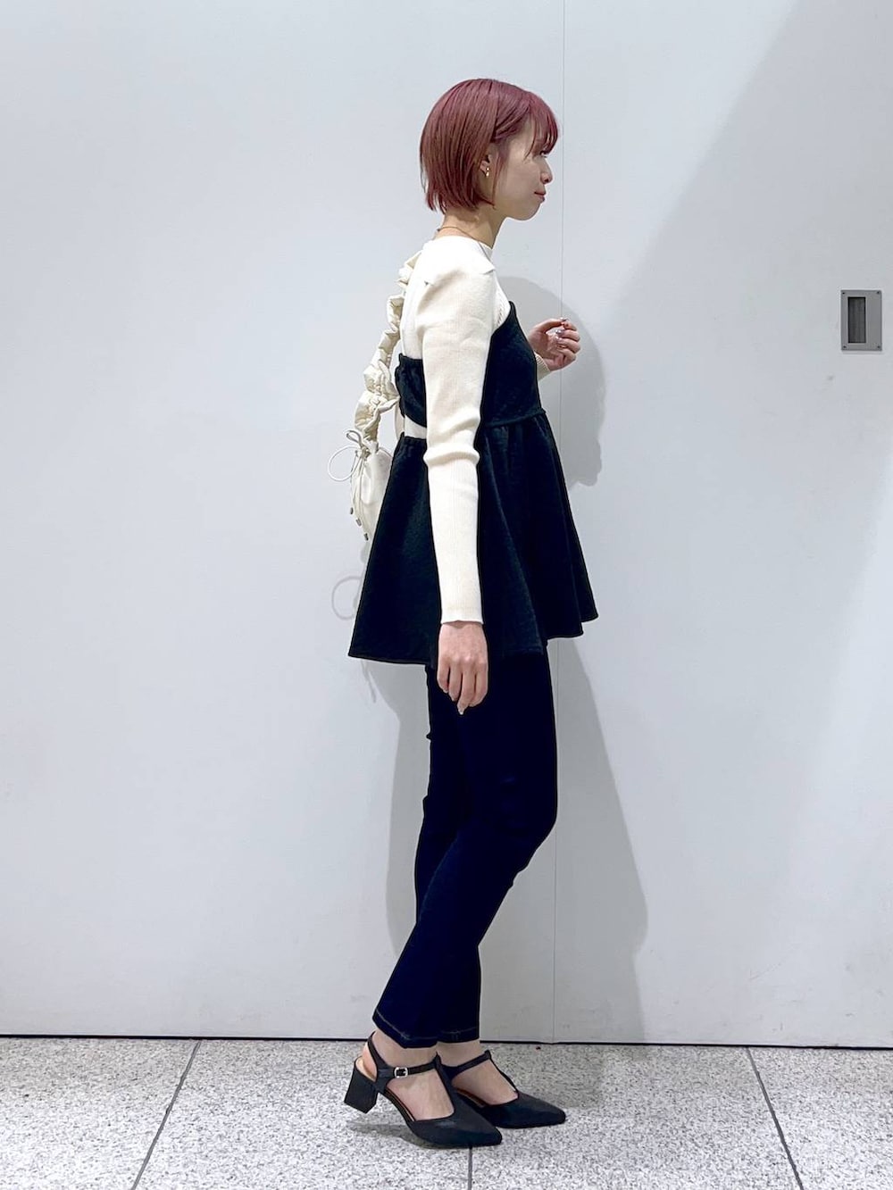 ブルー系のデニムパンツ、グリーン系のその他アウター、ホワイト系のハンドバッグを着用したレディースの秋コーディネートの5枚目の写真