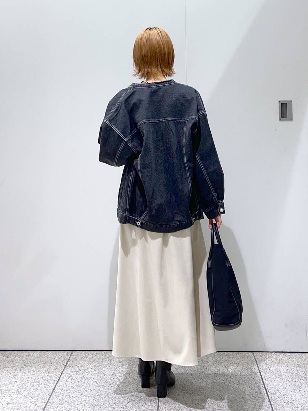 ホワイト系のワンピース、ブラック系のトートバッグ、ホワイト系のTシャツ/カットソーを着用したレディースの冬コーディネートの3枚目の写真